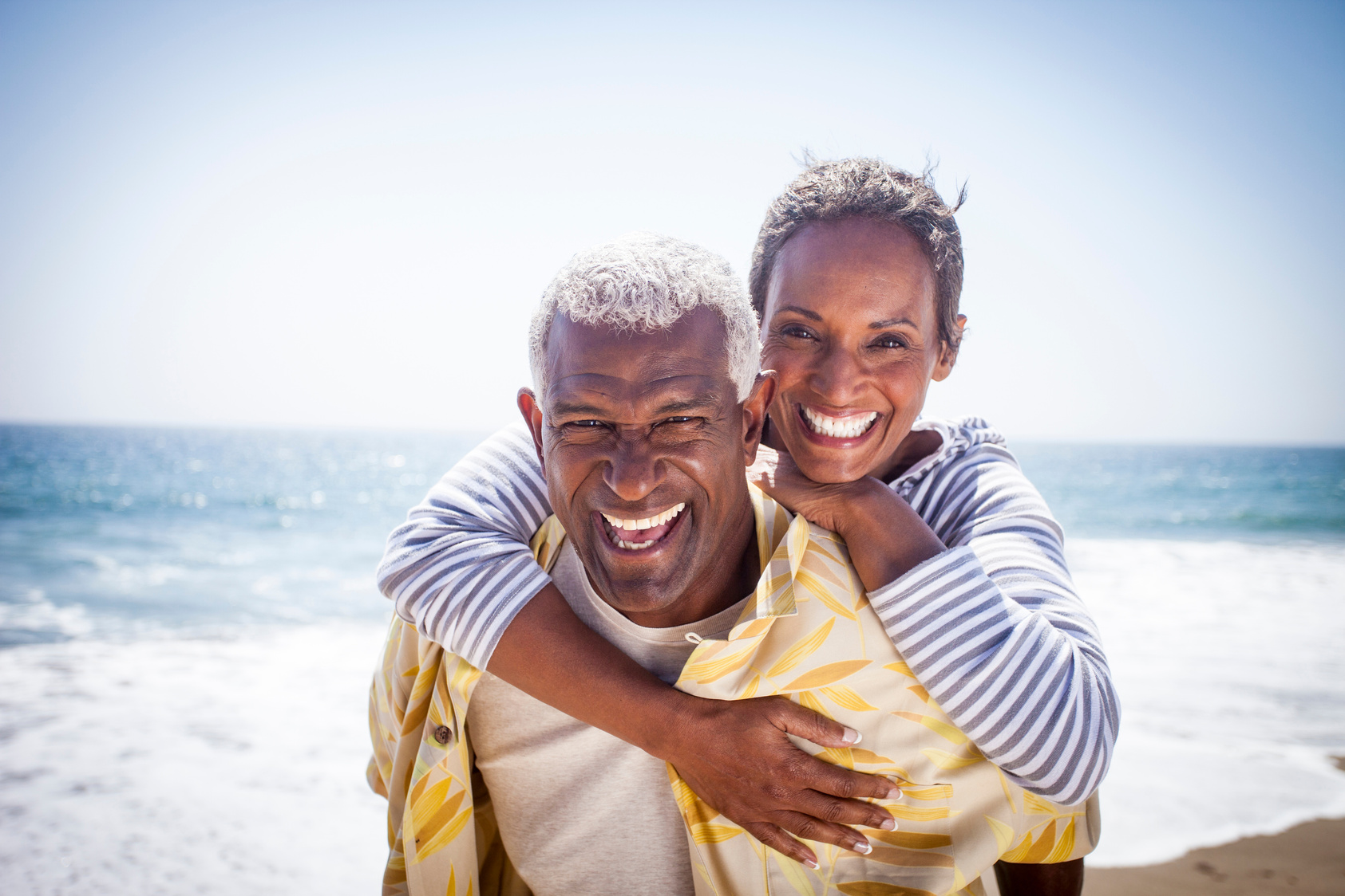 Happy Couple in Piggyback on the Beach